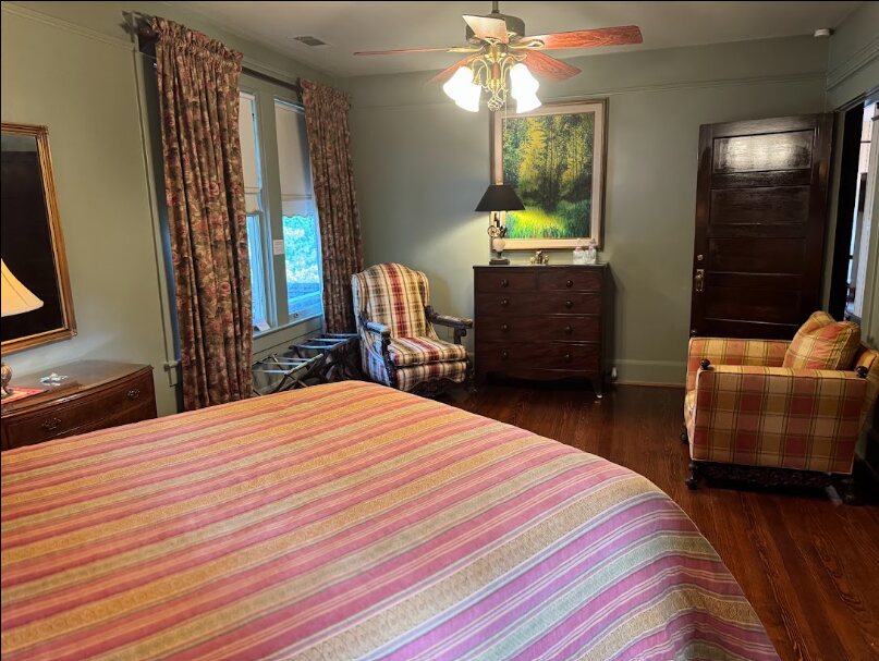 A Daisy Polk Inn guest room with hardwood floors and upholstered chairs